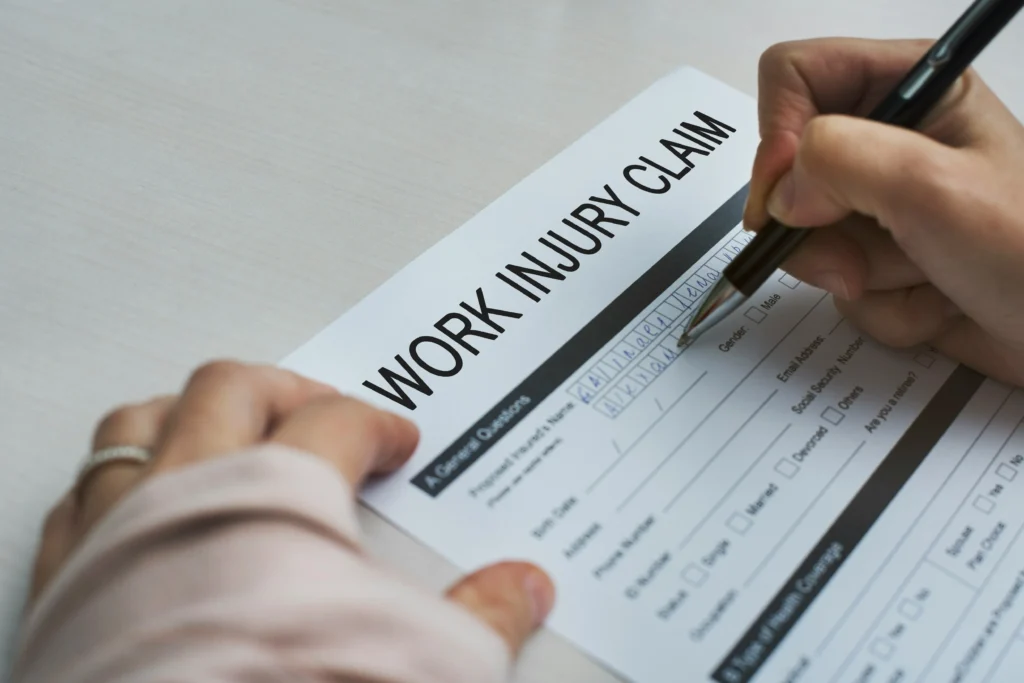 Person filling out work injury claim form for Illinois workers compensation lawyer