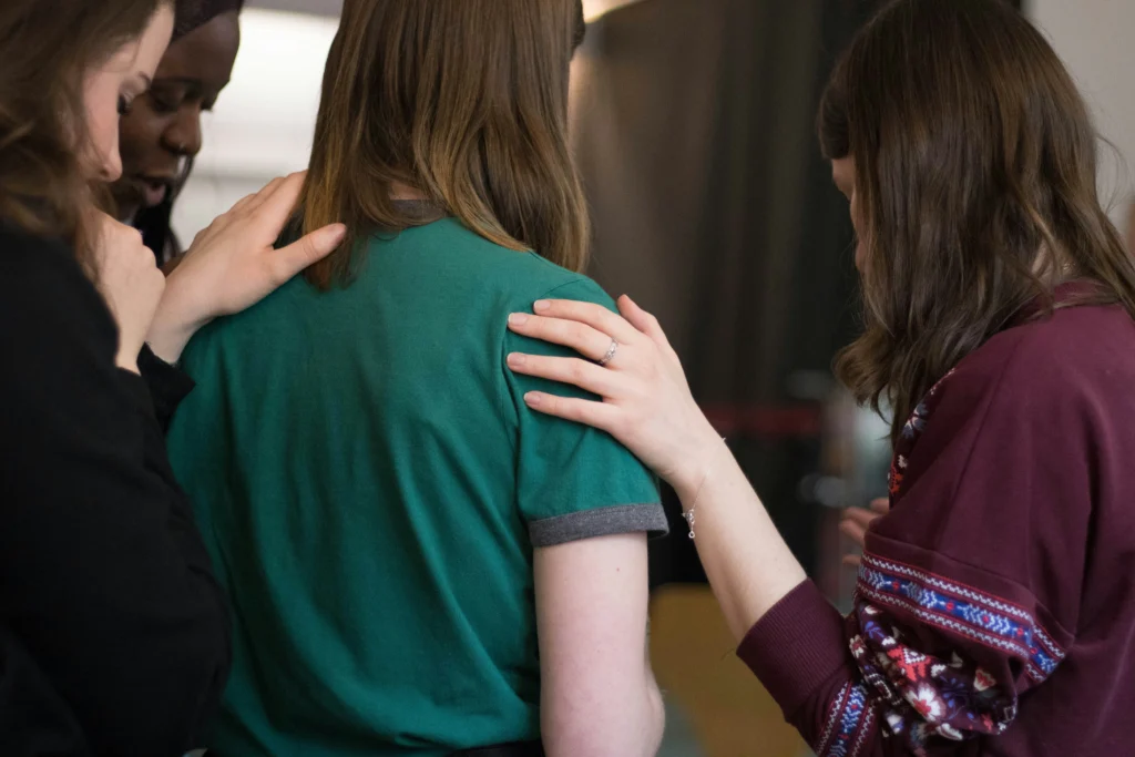 Sexual abuse attorney jands on a woman’s shoulder offering support