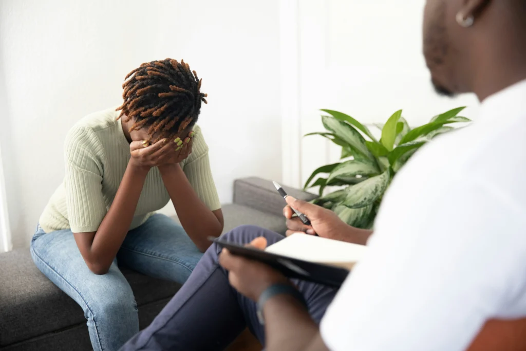 Woman in session, head in hands while speaking to a sexual abuse attorney