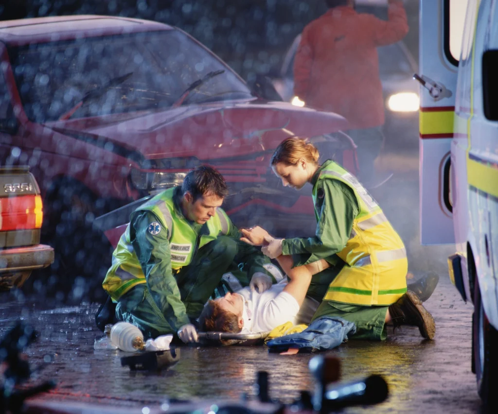 medical team assisting a man injured from a car accident