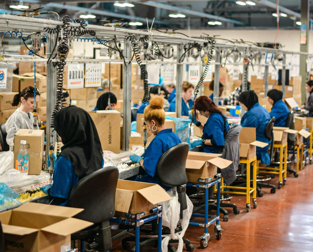 Assembly line staff performing repetitive tasks, highlighting causes of tendonitis workers' compensation settlements.