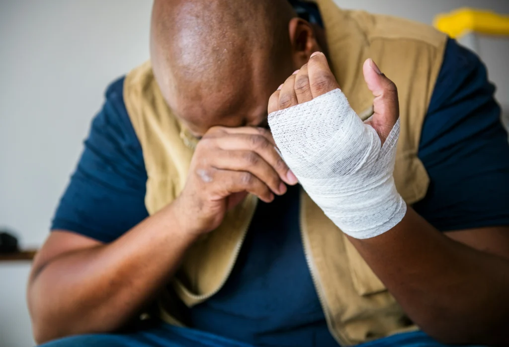 Injured worker holding bandaged hand needing help from a Chicago construction accident lawyer.