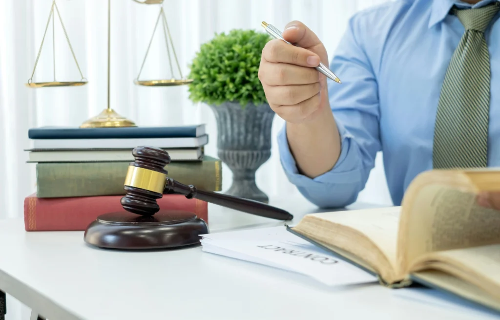 Lawyer at desk with gavel, contract, and law books
