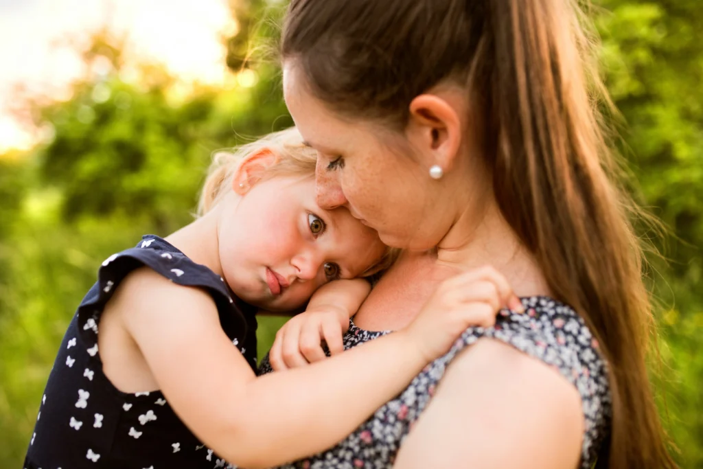 Mother comforting young daughter outdoors after talking with a Chicago wrongful death lawyer