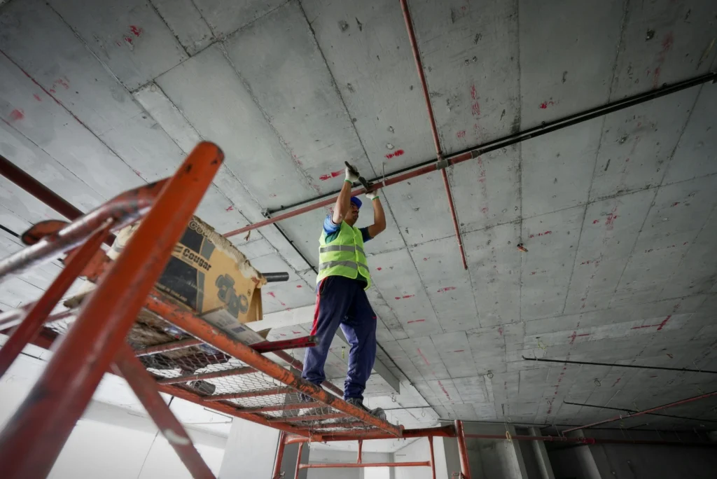 Worker on scaffolding highlighting job site dangers