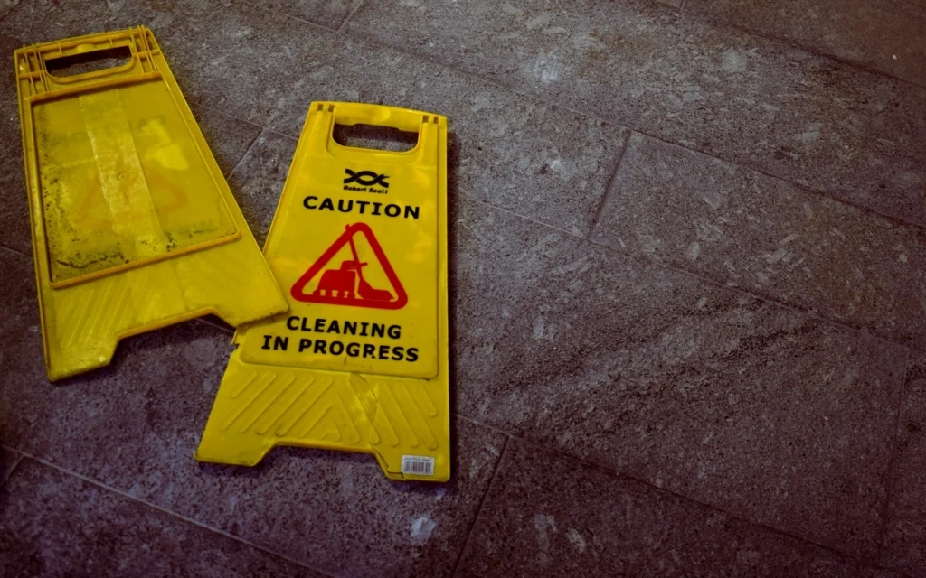 Cleaning sign on floor showing risk of a slip and fall injury at work.