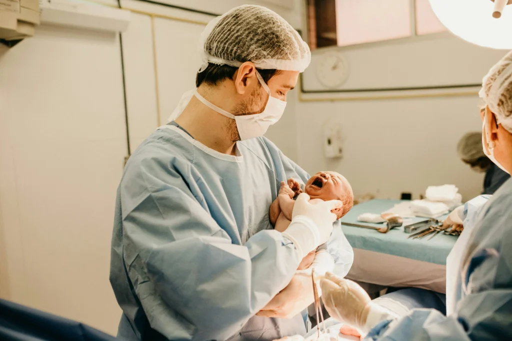 Doctor holding newborn after C-section injury, reflecting cases managed by the best birth injury lawyer