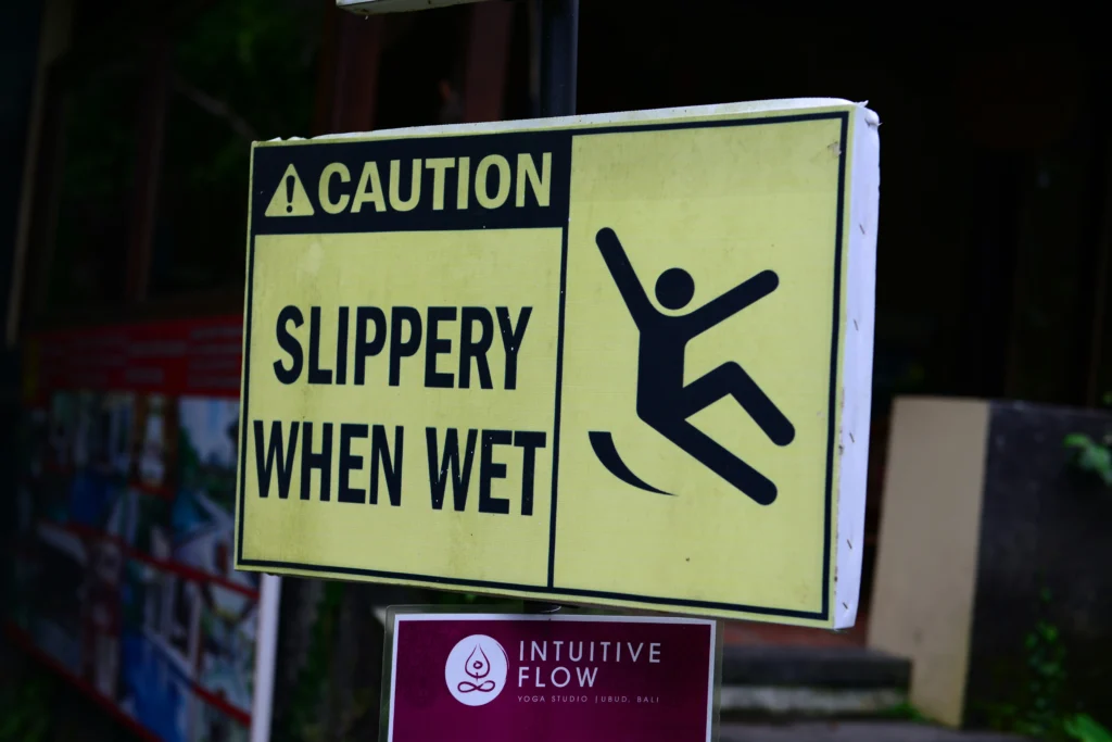 Slippery when wet caution sign preventing a slip and fall injury at work.